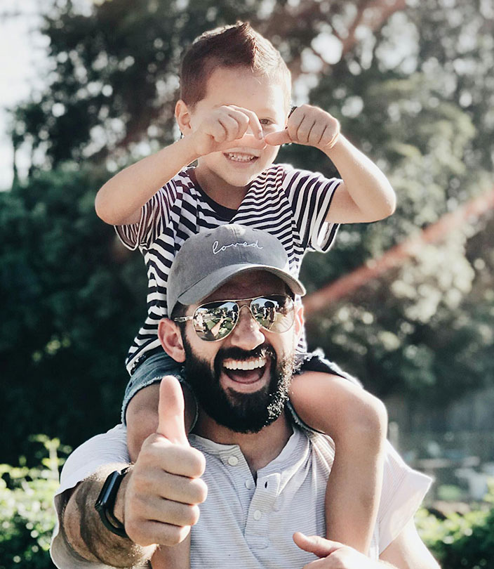 Child smiling with his father, representing confident development through early orthodontic care