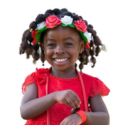 A child smiling in a red dress that is happy