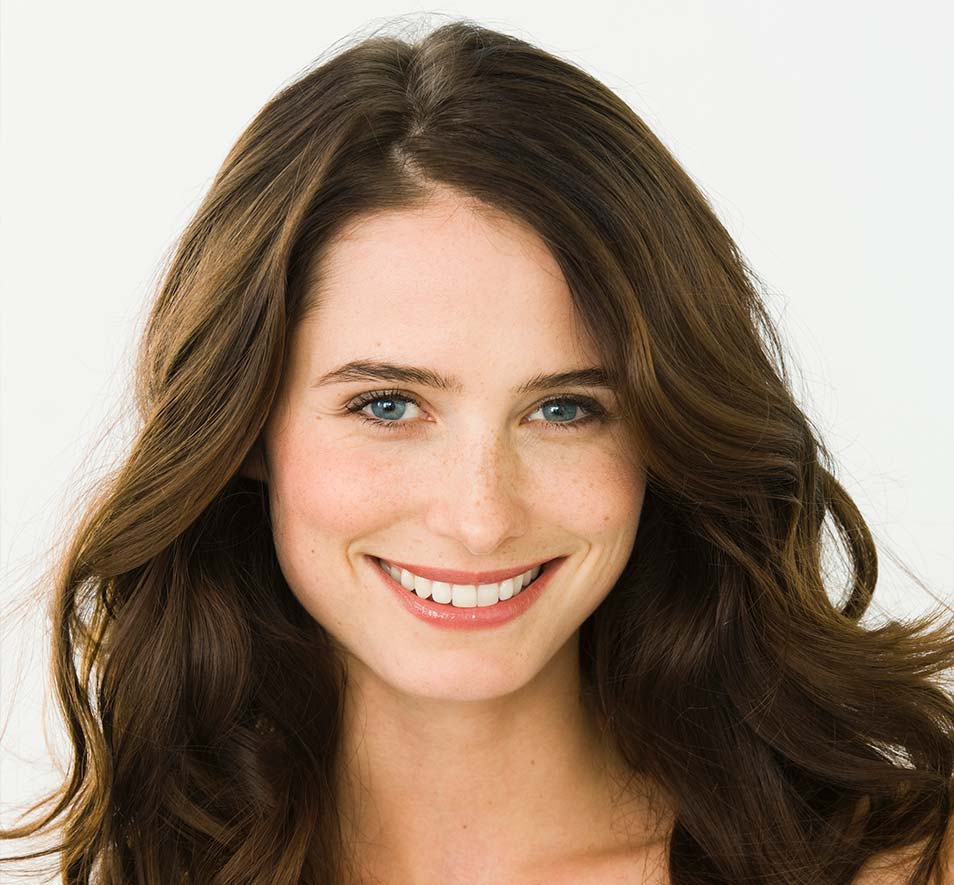 Woman smiling with straight teeth having retainers post orthodontics